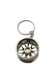 Detailaufnahme eines silbernen Felgen Schlüsselanhängers aus Metall mit glänzendem Chrom-Finish von hinten